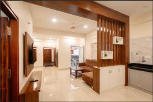a living room with a couch and a television at The Aetheria Service Apartment in Chikmagalūr