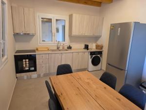 a kitchen with a table and a refrigerator at Apsila Suites Mykonos in Mikonos