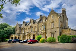 an old building with cars parked in front of it at Shendish Manor Hotel & Golf Course in Hemel Hempstead