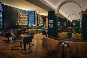 a bar with a couch and chairs and tables at Asher Adams, Autograph Collection in Salt Lake City