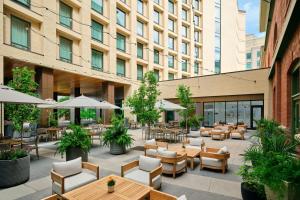 an outdoor patio with tables and chairs and a building at Asher Adams, Autograph Collection in Salt Lake City