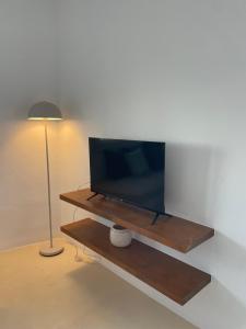 a flat screen tv sitting on a table next to a lamp at Silver Lining in Akrotiri