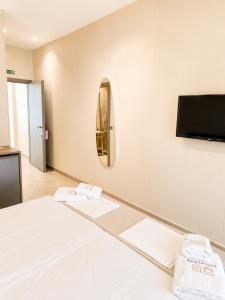 a room with a bed and a flat screen tv at UrbanBay Hotel & Spa in Kavála