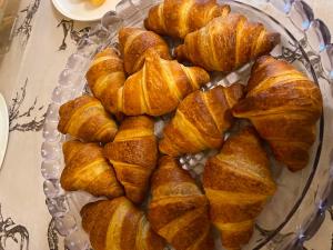 ein Stapel Croissants auf einem Glasteller auf einem Tisch in der Unterkunft Dependance GRIMANI in Ampezzo + 48 Fotos