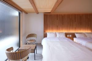 a hotel room with two beds and a chair at nedoko in Sumoto