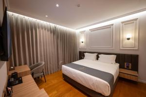 a hotel room with a bed and a chair in it at Hotel By Holiday in Rinas +56 photos