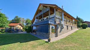 a large brick building with a balcony on a yard at Apartma AURA in Slovenske Konjice