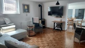 a living room with a couch and a tv and a table at Apartma AURA in Slovenske Konjice