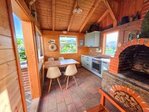 a kitchen with a table and a brick fireplace at Apartma AURA in Slovenske Konjice