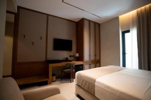 a hotel room with a bed and a desk with a computer at Carpe Diem Hotel in Borsh