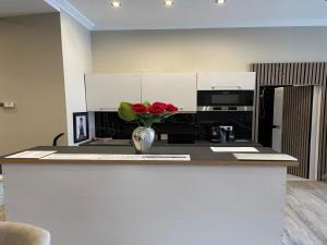 a vase of red roses sitting on a kitchen counter at Modern Suite in the Taunus in Bad Camberg