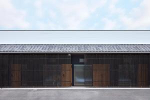 a facade of a building with wooden doors at nedoko in Sumoto