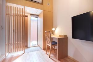 a room with a desk and a flat screen tv at nedoko in Sumoto