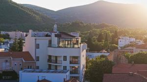 a building in a city with mountains in the background at Hotel Bulevar Mostar in Mostar