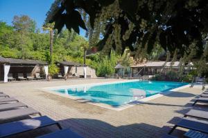 a swimming pool in a resort with lounge chairs at Hameau du Prat in Ribes