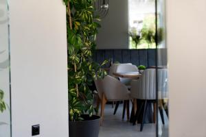 a dining room with plants and a table and chairs at Hotel Sea Sand in Sveti Vlas