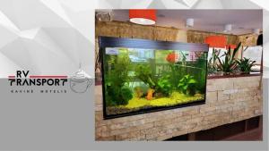 a fish tank on a brick wall in a room at RV kavinė motelis in Salaperaugis