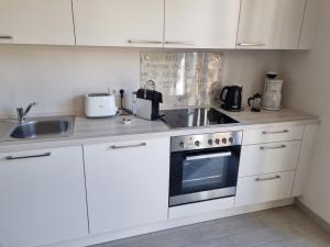 a kitchen with white cabinets and a sink and a stove at Business Lounge Potsdam in Potsdam