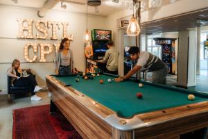 a group of people playing pool in a room at MEININGER Hotel Copenhagen in Copenhagen