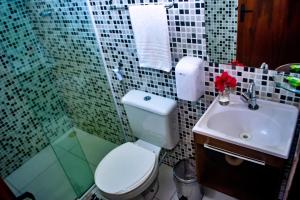 a bathroom with a toilet and a sink at Pousada Sitio Araça in São Miguel dos Milagres