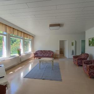 a living room with couches and a table and windows at Villa Aspen in Kokkola