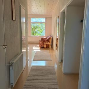 a hallway with a room with a chair and a window at Villa Aspen in Kokkola