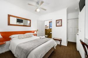 a bedroom with a bed and a ceiling fan at Abalone Guest House in Port Elizabeth +44 photos