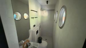 a bathroom with a toilet and a round window at Floatel Vilnius in Vilnius