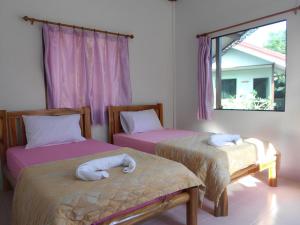a bedroom with two beds with towels on them at Na Chan Resort in Ban Khlong Khlung (1)