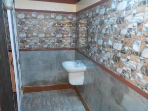 a bathroom with a toilet and a stone wall at Na Chan Resort in Ban Khlong Khlung (1) +168 photos