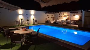 a swimming pool at night with a table next to it at RM MAISON by Rui & Mi in Tomar