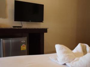 a hotel room with a bed with a tv and a pillow at Surintara Resort in Surin