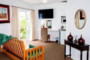 a living room with a bed and a desk at Abalone Guest House in Port Elizabeth