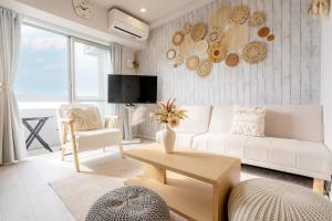 a living room with a white couch and a table at Ocean Front! New Built Apartment! SOU Resort YAKA in Kin