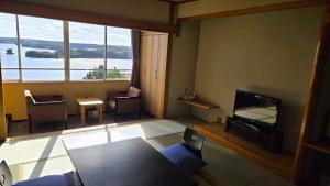 a living room with a tv and a large window at 賢島の宿みち潮 Kashikojima no yado Michishio in Shima