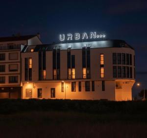 a building with a sign on top of it at night at URBAN Pensión in Melide