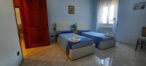 a room with two beds and a red door at A casa di Ely in Aulla
