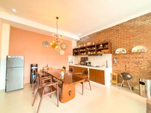 a dining room with a table and a brick wall at Emka Family Villa Malang in Malang