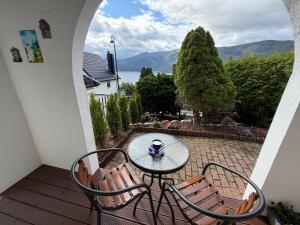 a table and chairs on a balcony with a view at Sukkertoppen Apartment in Ålesund