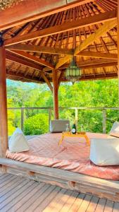 a bed on a deck with a wooden roof at La maison du Ruisseau in Saint-Louis