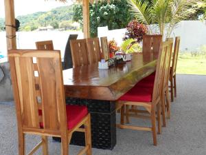 a wooden table with wooden chairs and a wooden at Silver Fern Beach Retreat in Sekotong