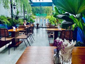 a restaurant with tables and chairs and plants at Ngan Ha Hotel - Ben Thanh Central in Ho Chi Minh City
