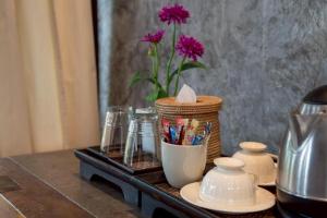 a table with a vase with purple flowers in it at Chababaancham Resort in Amphawa +63 photos