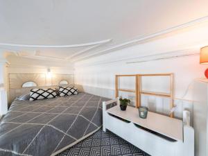 a bedroom with a large bed and a desk at Parenthèse en Ville in Arcachon