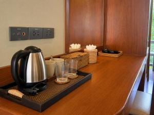 a tea kettle and glasses on a wooden counter at Flow Hua Hin - Ice Bath and Villa in Hua Hin