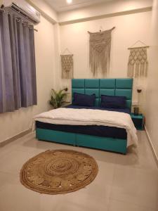 a bedroom with a blue bed and a rug at Ashirwad Stay in Rishīkesh