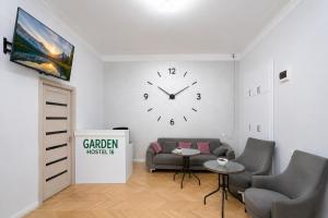 a room with a couch and a clock on the wall at Garden Hostel 16 in Yerevan