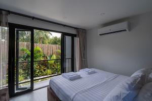 a bedroom with a bed and a large window at Aranya Bliss Villa 105 in Ban Madua Wan +44 photos