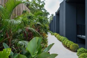 a path through a garden with plants next to a building at Aranya Bliss Villa 105 in Ban Madua Wan