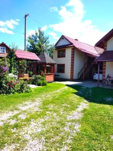 a house with a grass yard and a house at Shelter Pid Lypamy in Mykulychyn